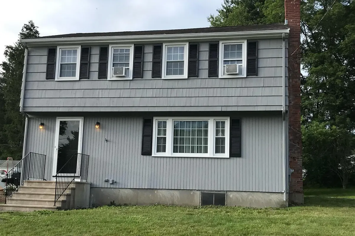 Two-story house after a full exterior repaint in gray with black shutters