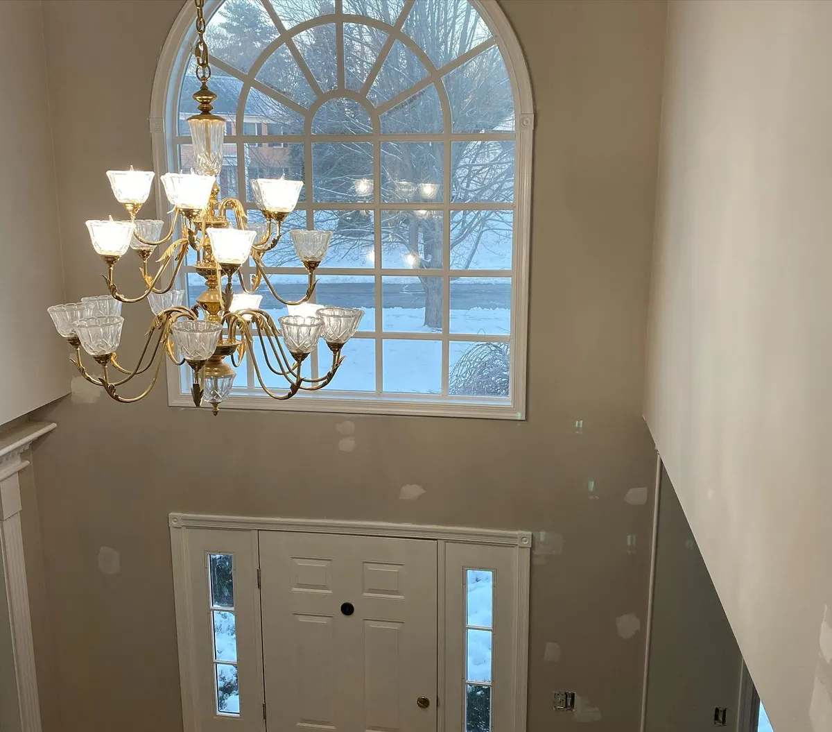 Two-story foyer with arched window after interior repaint