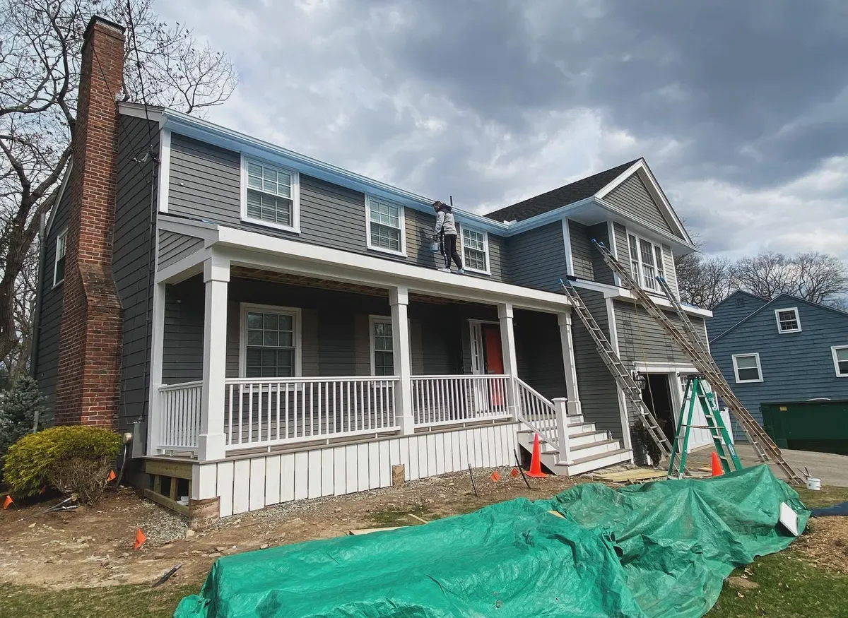 Gray colonial with white porch in Needham during painting